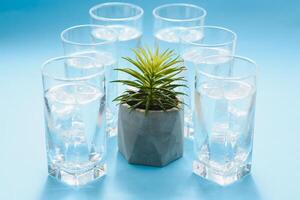 glasses with pure water and shadows on blue surface photo