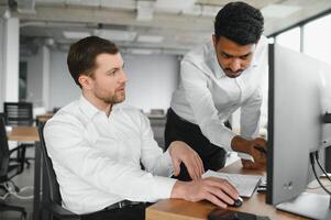 Two successful trader in formalwear pointing at display, analyzing stat and dynamic on forex charts, working in office together photo