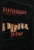 ahumado tradicional ahumado carne. un composición de ahumado frío cortes en un negro antecedentes. foto