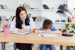 Child psychologist attending small boy. The concept of psychological assistance to children. photo