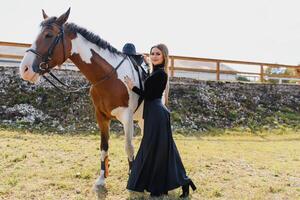 retrato de joven bonito alegre mujer con caballo a verano foto