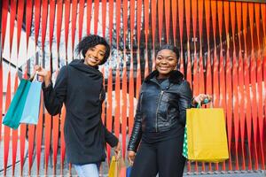 young black women going shopping. African American girls with shopping bags go shopping photo