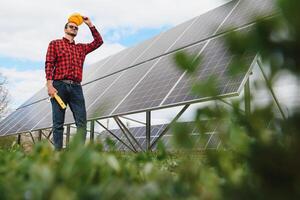 joven técnico instalando solar paneles en fábrica techo foto