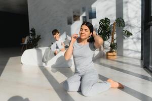 happy woman having fun with adorable son in pajamas in bedroom on mothers day. photo