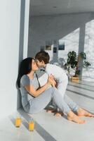 Young mother with her 4 years old little son dressed in pajamas are relaxing and playing in the bedroom at the weekend together, lazy morning. photo