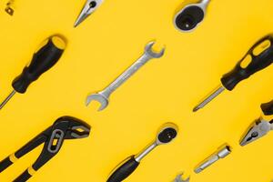 conjunto de varios construcción herramientas. herramientas para hogar reparar. trabajo a un construcción sitio. en un amarillo antecedentes. categóricamente. flatlay foto