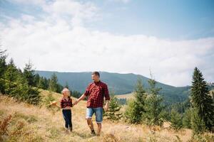 Happy father and little child are walking in the mountains. Father's Day. vacation in the national park. photo