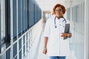 africano americano enfermero con portapapeles en hospital foto