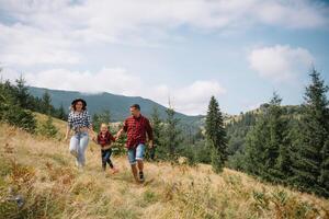 joven familia con niño descansando en un montaña foto