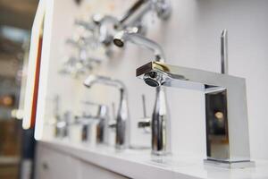 showcase in the store with faucets for the kitchen and bathroom photo