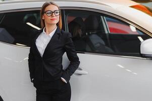 business woman in auto salon. concept of female driver photo