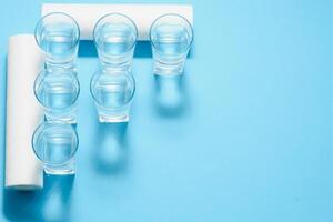 A glass of water on the background of filter cartridges photo