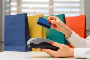 Close up of hand using credit card swiping machine to pay. credit card payment through a shopping terminal. Credit card payment for new clothing collection photo