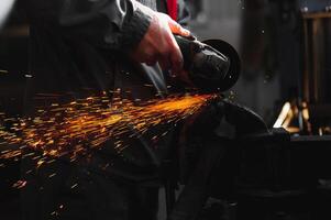 sawing metal. sparks frying over the working table during metal grinding photo