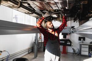 Auto mechanic working at auto repair shop photo