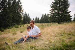 Happy father and little child are walking in the mountains. Father's Day. vacation in the national park photo