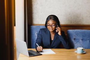 Pensive black businesswoman using tablet computer in coffee shop photo