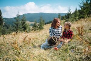 Mom hugs a little son at the top of the mountain. Square. The concept of family, yoga, travel. photo