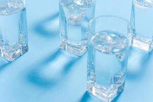 glasses with water on blue background. clean water concept photo