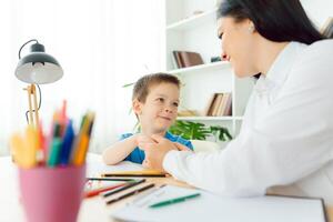 Child psychologist working with boy in office photo