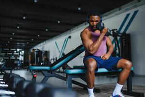 hombre hacer ejercicio con pesas a un gimnasia, horizontal disparo. foto