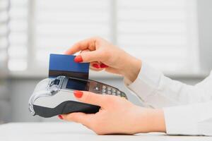 Hand with credit card swipe through terminal for sale in supermarket. credit card payment through a shopping terminal at shopping photo