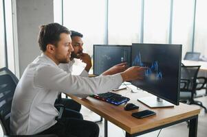 Two diverse crypto traders brokers stock exchange market investors discussing trading charts research reports growth using pc computer looking at screen analyzing invest strategy, financial risks. photo