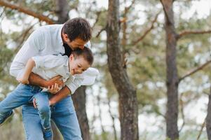 padre y hijo tener divertido juntos en naturaleza. padre y hijo jugando. personas teniendo divertido al aire libre. concepto de simpático familia. foto