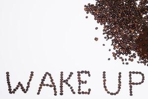 Words wake up from coffee beans isolated on white background photo