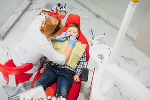 Female dentist and child in a dentist office photo