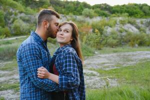 Couple enjoying beautiful views on the mountains, while traveling with backpacks in the mountains during the summer vacations photo