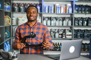 retrato de un hermoso africano vendedor en un auto partes almacenar. el concepto de coche reparar foto