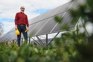 joven técnico instalando solar paneles en fábrica techo foto