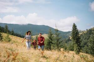 Father and child hiking in scenic mountains. Dad and son enjoying the view from the mountain top in Carpathian mountains photo