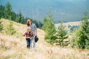 Mom hugs a little daughter at the top of the mountain. Square. The concept of family, yoga, travel photo