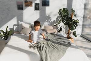pequeño chico vistiendo blanco pijama en cama foto