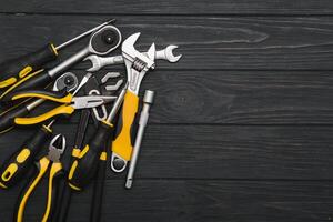 Set of assorted work carpentry and locksmith tools on a dark wooden background with copy space photo