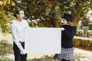 couple funny mimes holding sign photo