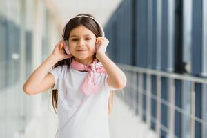 elegante niña escuchando a música rosado auriculares foto