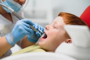 Little boy having his teeth examined by a dentist photo