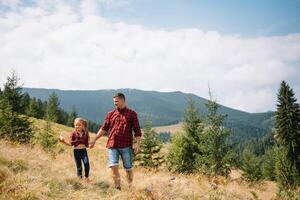 Happy father and little child are walking in the mountains. Father's Day. vacation in the national park. photo