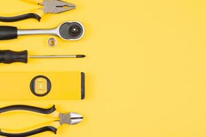 Carpenter tools set on yellow background, top view. photo