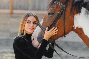 Portrait of young pretty cheerful woman with horse at summer photo