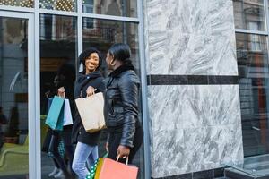 young black women going shopping. African American girls with shopping bags go shopping photo