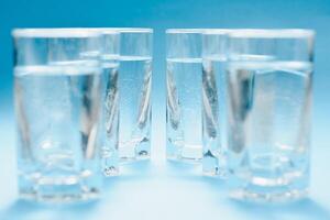 Glasses of water on a paper background. Drawing shadows. Classic Blue color. clean water concept photo