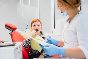 hembra dentista y niño en un dentista oficina foto