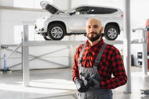 Mechanic working under car at the repair garage. Auto mechanic working in garage. Repair service. photo