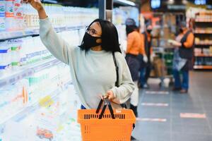 African american woman with shopping cart trolley in the supermarket store photo