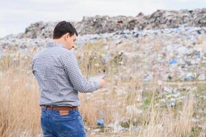 basura reciclaje concepto. hombre en basurero acuerdo el ambiente limpio. ecológico problemas. foto