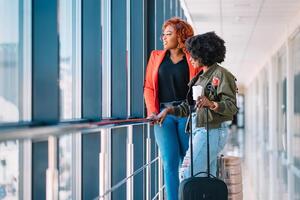 Two african girls with suitcases at the airport. The concept of travel and vacation. photo